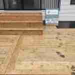 Newly built wooden backyard deck with stairs at a residential home